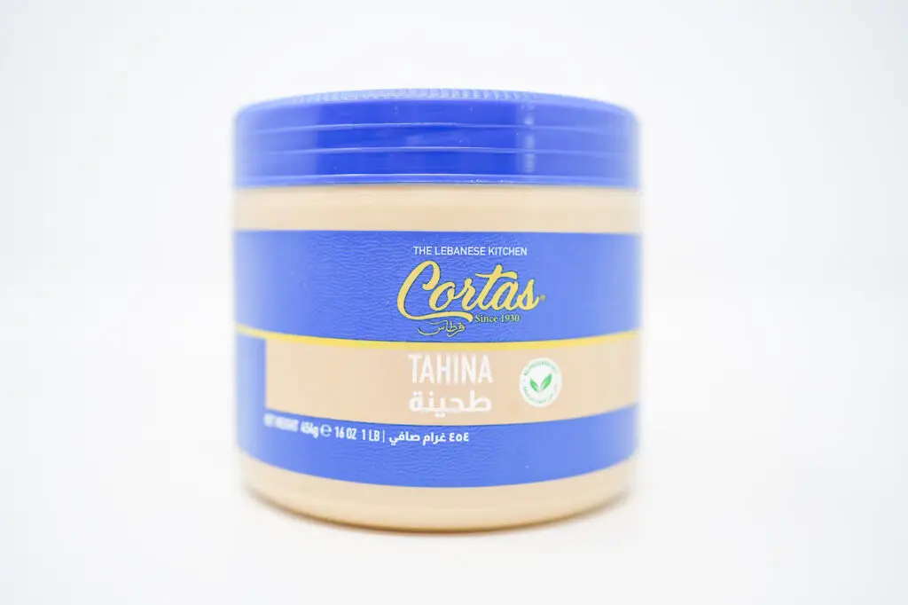 A jar of Cortas tahini on a completely white background, emphasizing the smooth, creamy sesame paste within, with the Cortas logo clearly visible on the label, symbolizing the brand's commitment to quality and purity in its ingredients.







