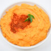 A bowl of creamy Paprika Mashed Sweet Potatoes, garnished with a sprinkle of smoked paprika and freshly chopped parsley.