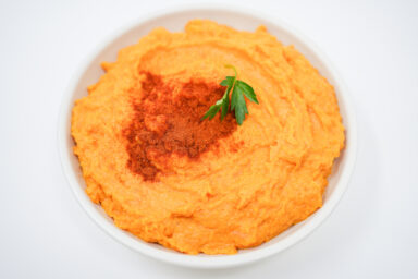 A bowl of creamy Paprika Mashed Sweet Potatoes, garnished with a sprinkle of smoked paprika and freshly chopped parsley.
